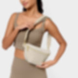Model wearing the Katie Loxton Nylon Luxe Belt Bag in Chalk crossbody-style, demonstrating its adjustable wide strap and casu