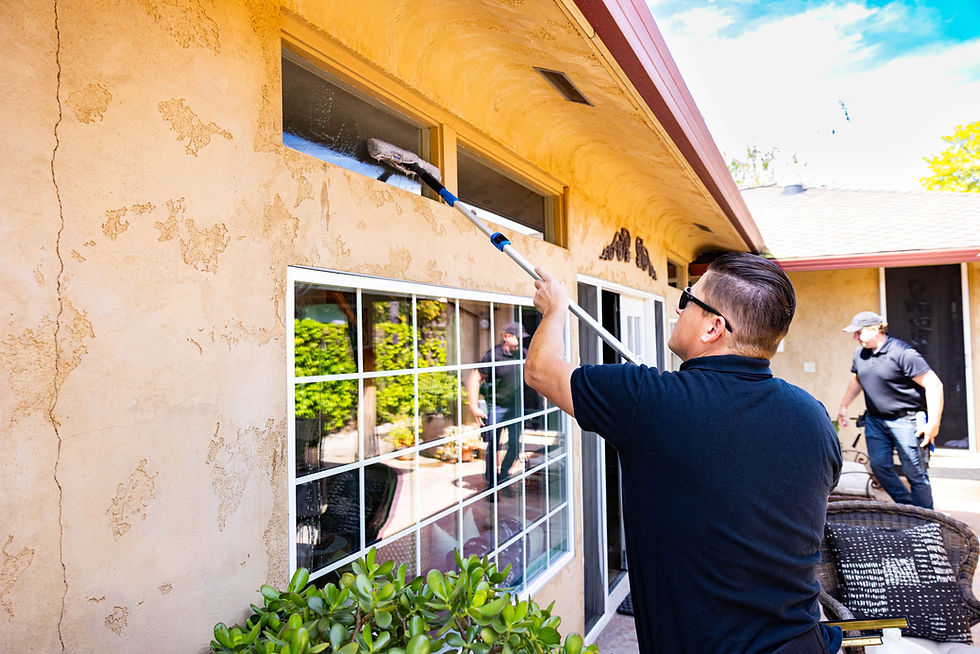 Two hard working men using tools outside to clean house. Clean windows, gutters, solar panels and pressure wash.