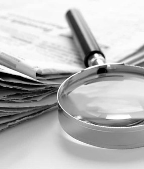 magnifying glass on top of newspapers