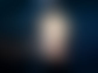 A person holds a glowing light bulb with digital symbols and graphs floating around, suggesting innovation. Background is dark and urban.