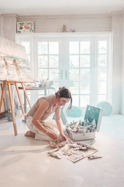 Artist Lauren Esplin in her sunlit art studio working on her contemporary coastal artworks.