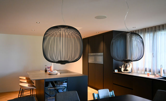 Dining room and kitchen with lights from Flos