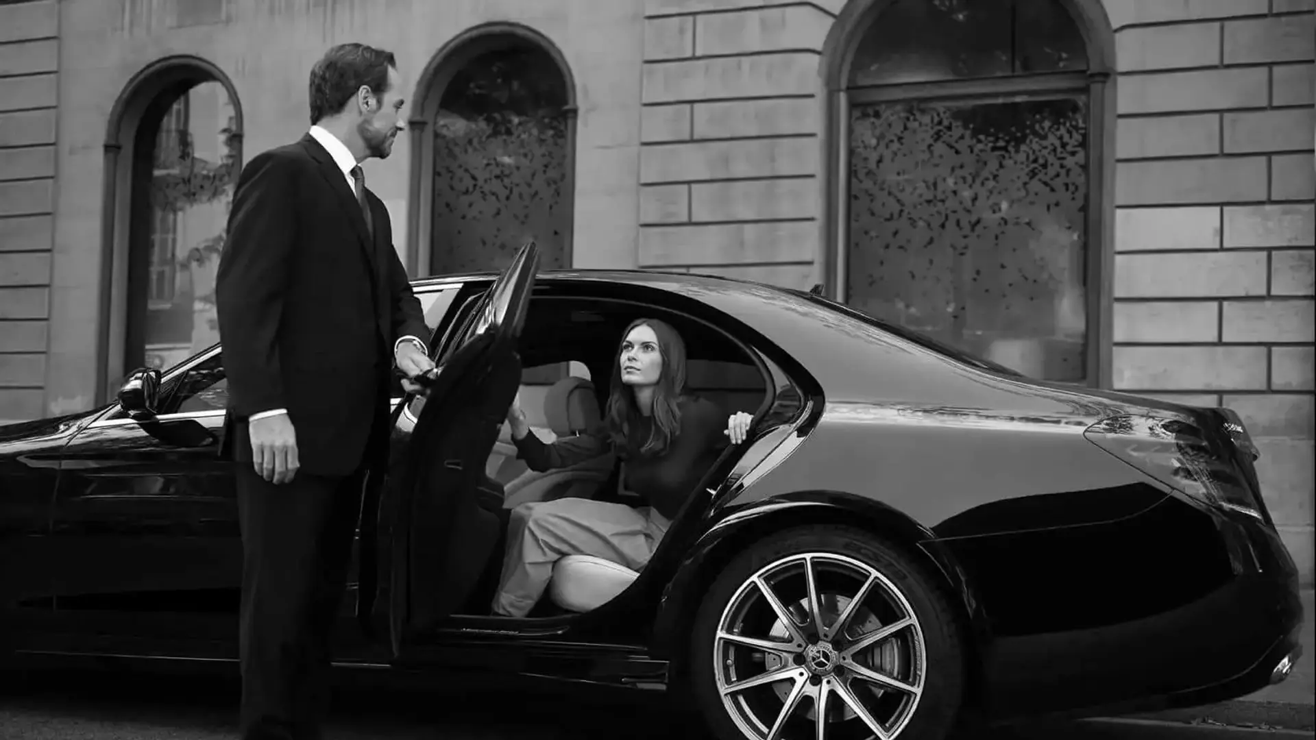 Chauffeur opening the door of a Mercedes S-Class for a VIP arrival