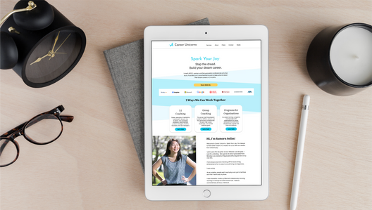 Wood desk with clock, eye glasses, candle, and iPad featuring Website Design for Career Unicorns by Logodentity Designer Ashley Shelton