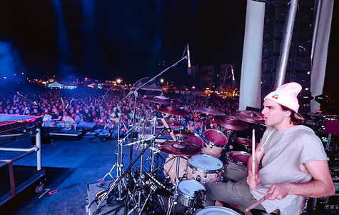 Eli Cherry performing drums with San Holo in front of a large crowd