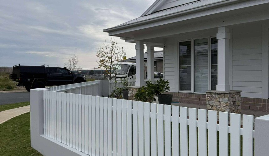 Charming & Decorative Front Yard Fences - White picket fence surrounding a landscaped front yard
