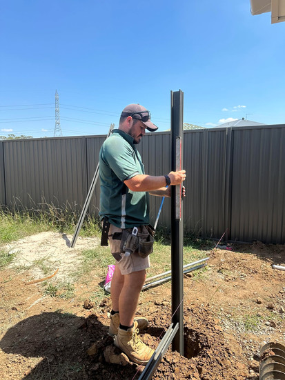 Joel prepares solid foundations by digging post holes with precision.