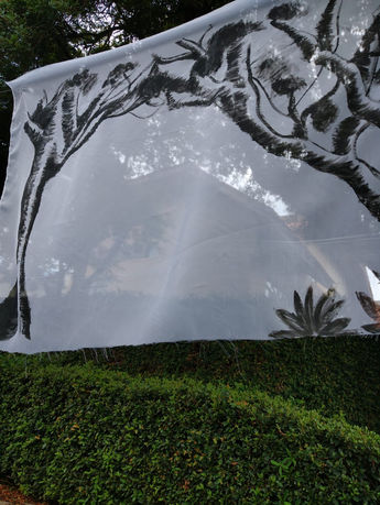 Imagem 1 - "Lembrete do Habitar". Fotografia digital da intervenção urbana realizada no bairro Bom Retiro - Curitiba/PR. Pintura acrílica em tecido Voil e fio de nylon. 140 X 90 cm. 2023.