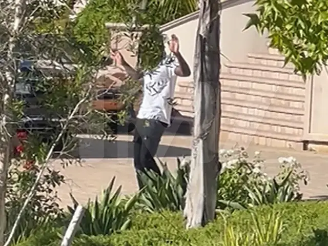 Polo G exits Los Angeles home with his hands in the air [Photo Courtesy: TMZ]