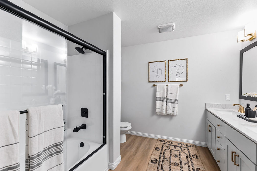 Modern bathroom with glass shower doors, vanity lighting, and decorative accents.