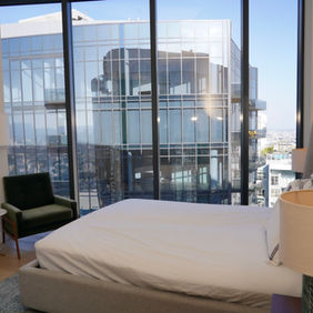 Modern bedroom at Circa in Downtown Los Angeles with floor-to-ceiling windows and city views.