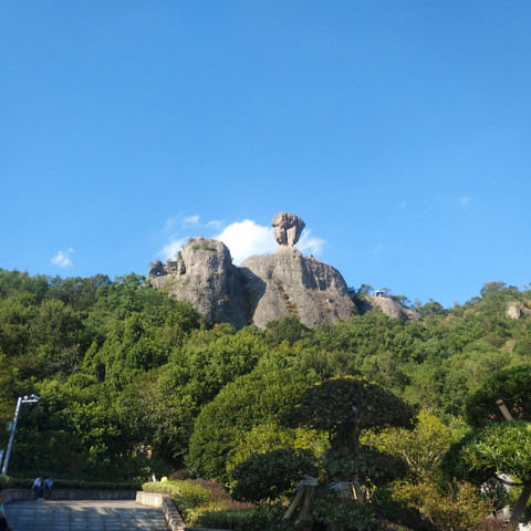 Fang Mountain, Taizhou, China. Shot of a pointy rock with trees around it.