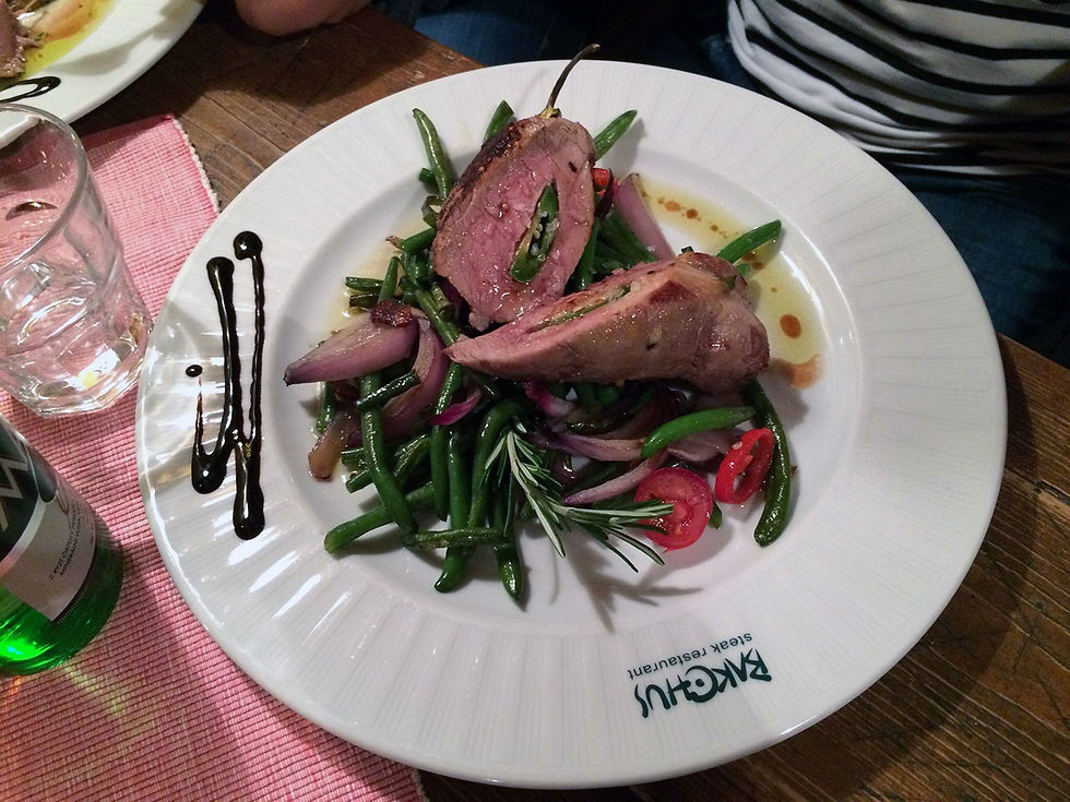 Steak vepřový s fazolkami na talíři v restauraci.