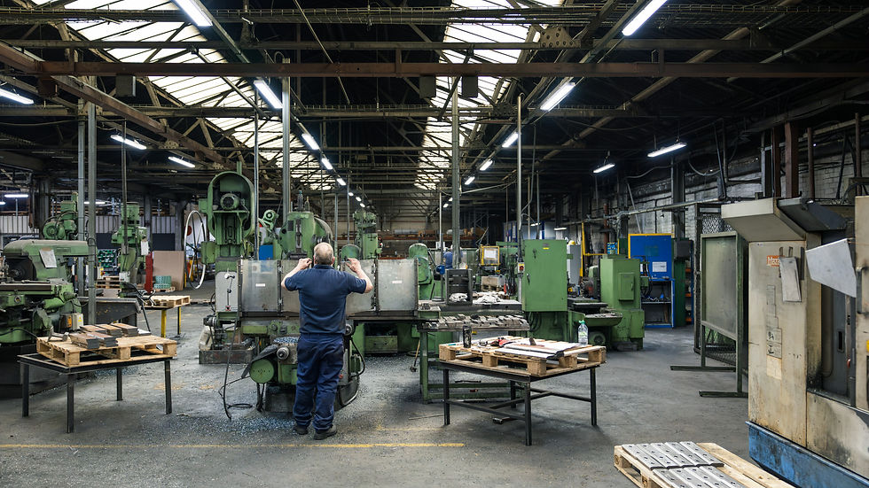 Workers handling glowing steel in a fabrication workshop