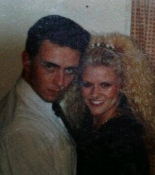 A photo taken of a couple in the 1980s - he is dark and handsome and posing dramatically - she is blonde with a lot of curly hair and smiling