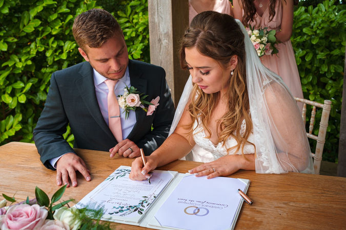 The couple sign their wedding certificate at Trevenna