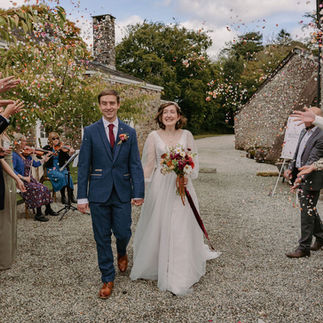 A couple exit their wedding ceremony at Boconnion