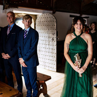 A bridesmaid smiles at a ceremony at Pentillie Castle