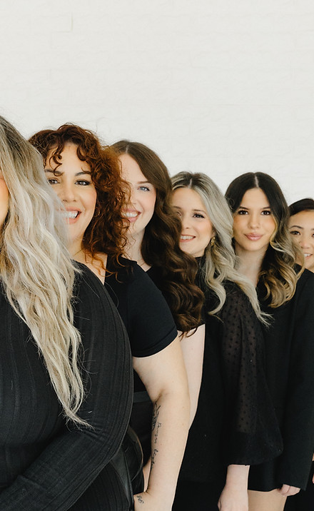 Professional hair and makeup artist team posing together.