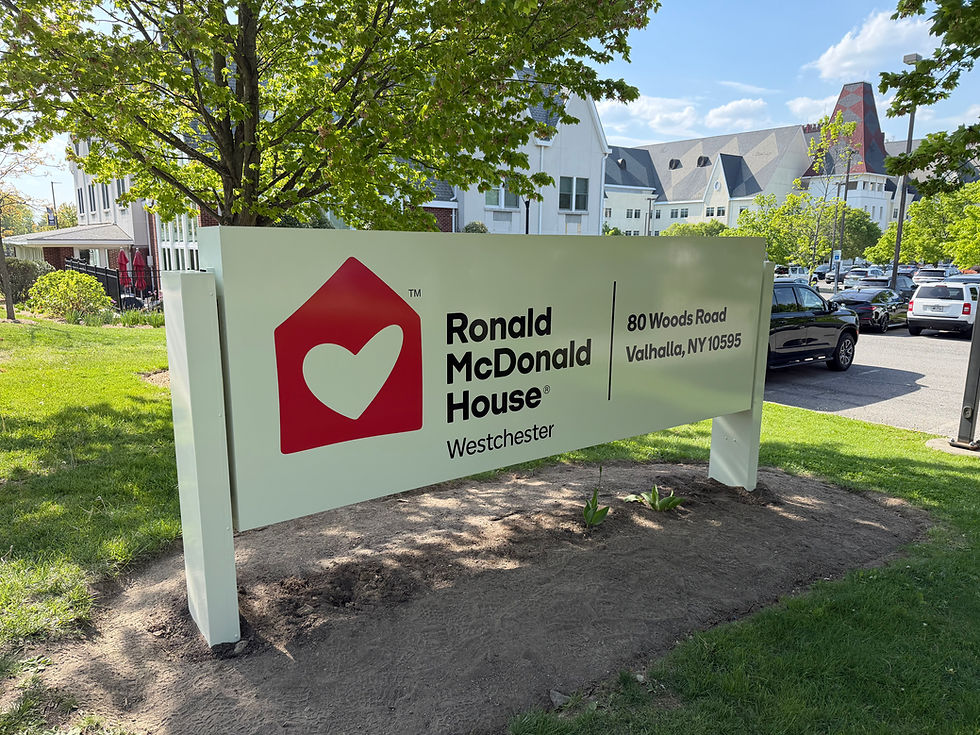 Updated vinyl-wrapped ground sign for Ronald McDonald House Westchester in Valhalla, NY, featuring the organization's current house-and-heart logo and refreshed branding.