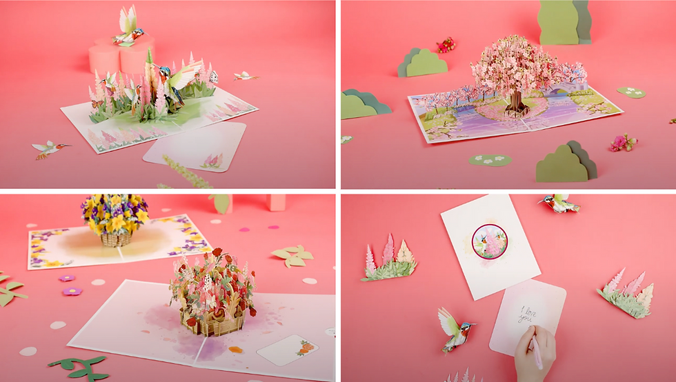 Pop-up cards on a pink background feature flowers, trees, and birds. One card shows "I love you" handwritten. Bright, whimsical mood.