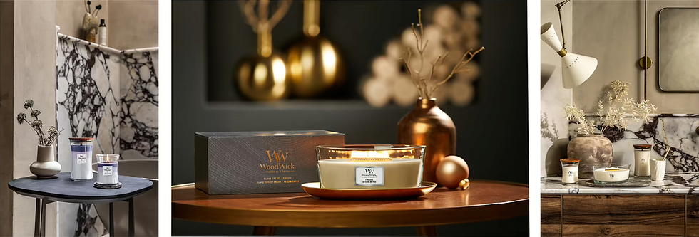 Elegant candles on tables with marble and wood accents, gold vases, and soft lighting. Labels read "WoodWick" and "Trilogy." Cozy ambiance.