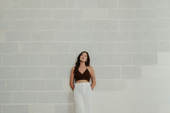 Femme en tenue légère dans un décor minimaliste, ambiance épurée et élégante.