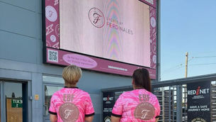EBF team in branded football shirts standing in front of digital screens at Bromley FC stadium