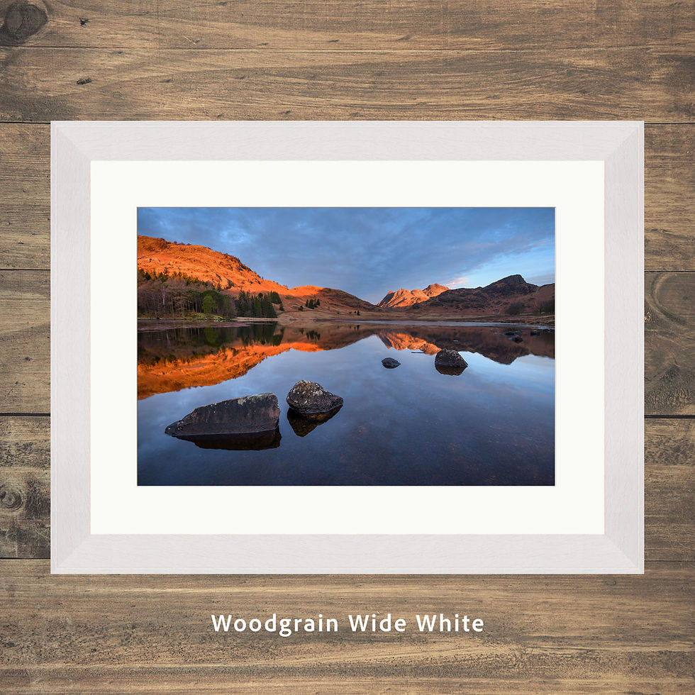Thumbnail: calm morning reflections at Blea Tarn, with golden light on The Langdale Pikes in The Lake District National Park, UK.