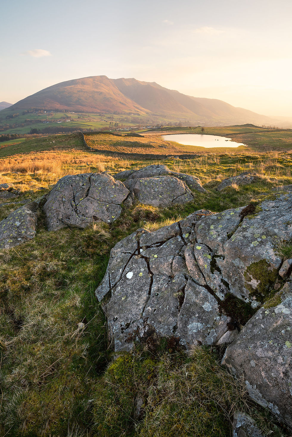 Thumbnail: a beautiful hazy spring morning with golden sunshine at Tewet Tarn with breathtaking views to Blencathra in The Lake District