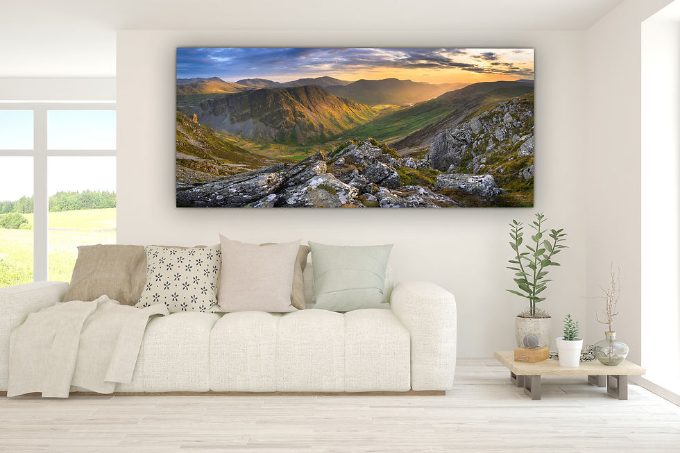 A panoramic view of Honister Pass, Fleetwith Pike and the Buttermere valleys with golden hour sunlight on a summer evening.