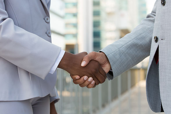 Multiethnic leaders greeting each other in city. Closeup of business man and woman shaking