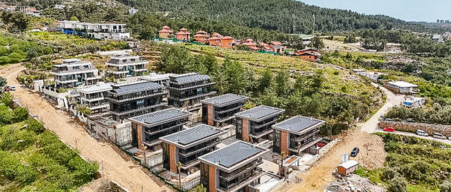 Aerial photograph of the villas and green hillside setting