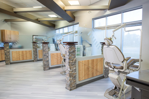 Dental office with modern beige chairs, stone and wood partition walls, and large windows. The setting is clean and well-lit. Viewpoint Photography