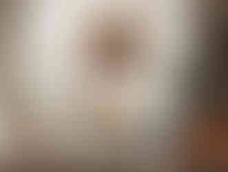 Living room with beige sofa, vibrant flowers on glass table, and a large framed family portrait on the wall. Cozy and warm ambiance. Viewpoint Photography Edmonton