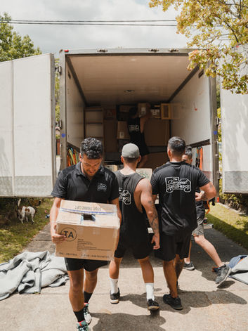 Team of movers loading boxes into a moving truck