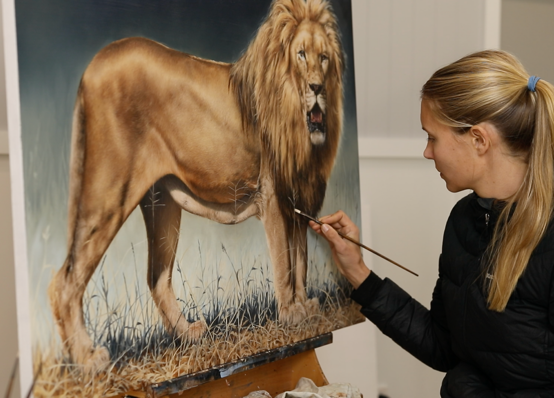 Carla Grace wildlife artist painting an African lion in oil on canvas. equustyle.com carlagraceart.com