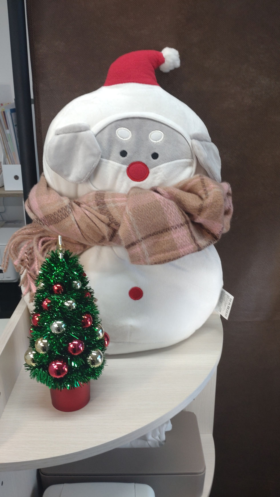 雪だるまの格好をした犬の人形にマフラーが巻いてある