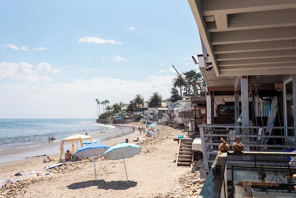 Eye-level view of a tranquil beachfront with lounge chairs and umbrellas