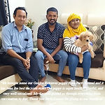 "Happy family sitting on a sofa with their new Golden Retriever puppy from Parth Kennel."