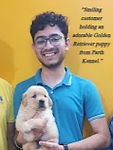 "Smiling customer holding an adorable Golden Retriever puppy from Parth Kennel."