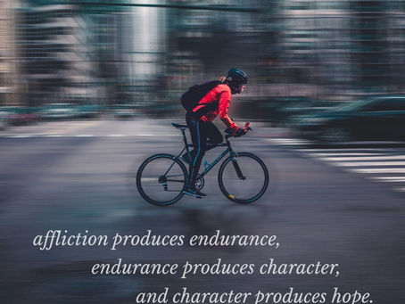 a person on bicycle with blurred city scape in background