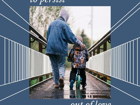 adult holding the bike of a youth learning to ride