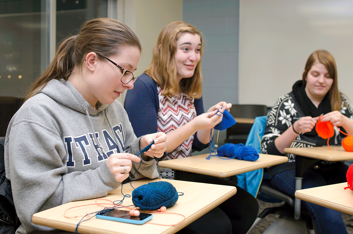Photo shows three college students knitting for Project Sunshine. I (Sabina) am posed in the middle.