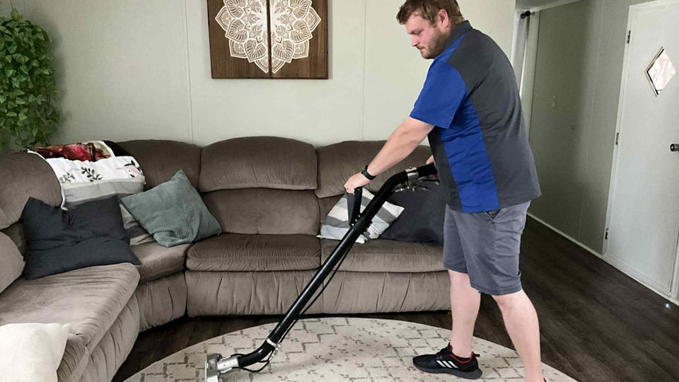 James Shea cleaning rugs inside a Tulsa home with professional equipment.