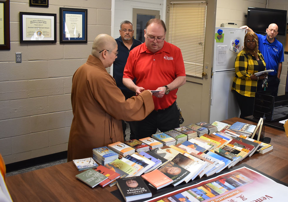 北卡佛光山監寺監寺妙舟法師向典獄長 Embery L. Morton 介紹了佛光山開山祖師星雲大師的自傳小叢書。(海闊拍攝)