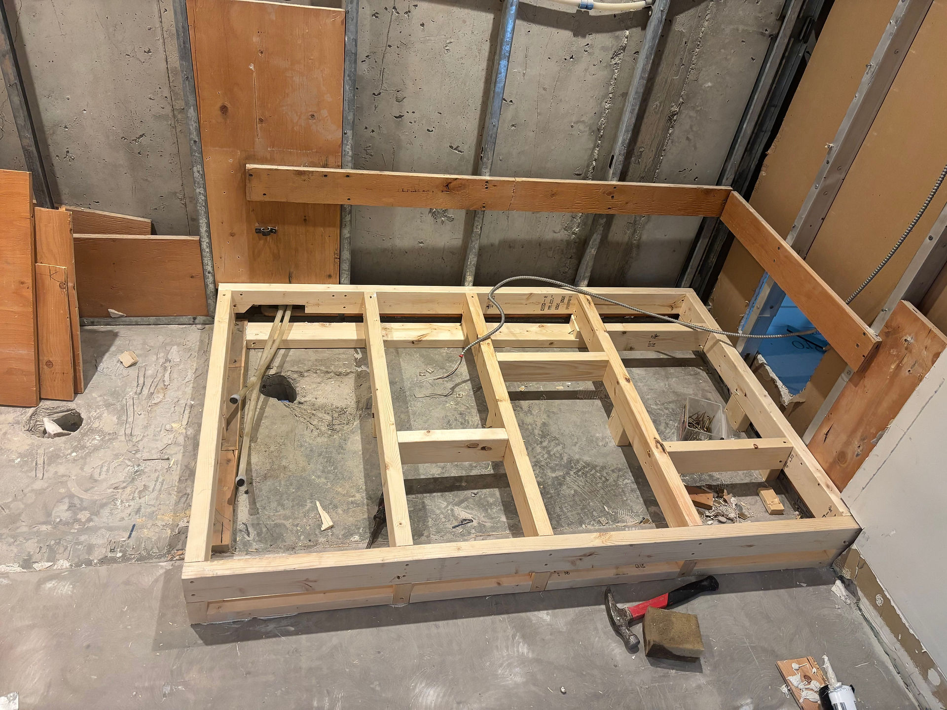 Bathroom subfloor framing and structural wood joist installation during Vancouver condo bathroom renovation