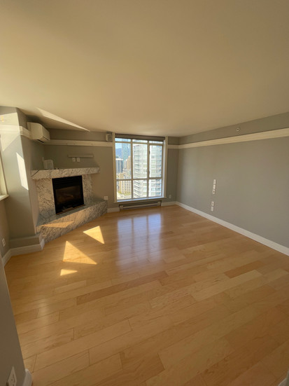 Refinished oak hardwood floors in Vancouver high-rise condo after professional sanding and sealing.