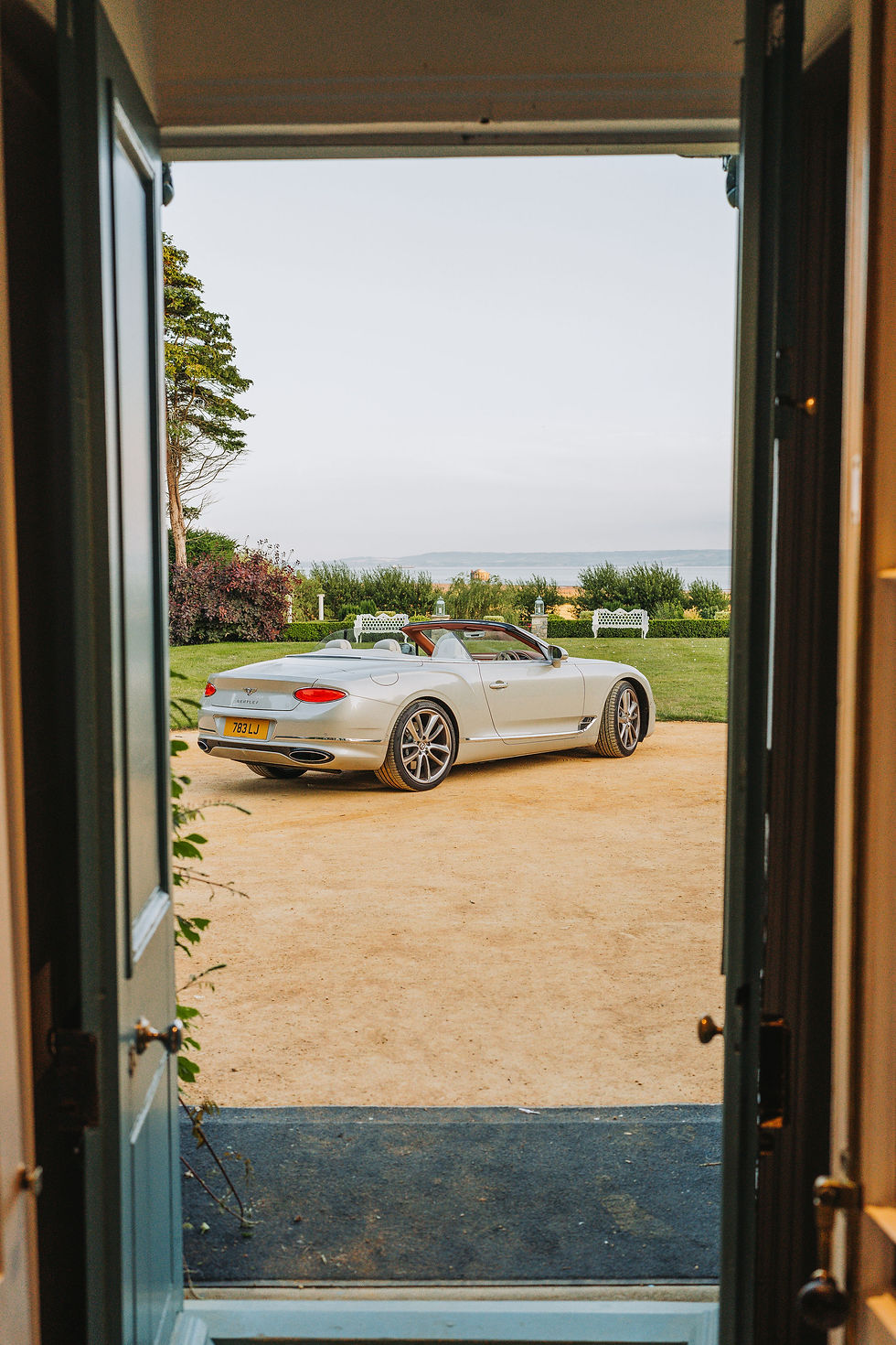 Bentley Continental GTC with its roof down overlooking the sea view at Gileston Manor