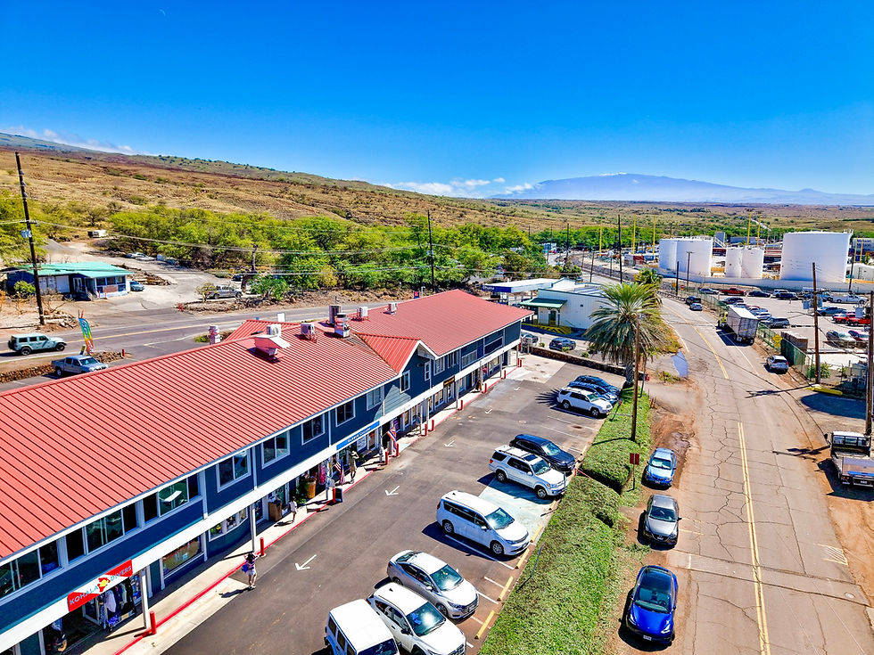 Aerial view of Kawaihae Shopping Center with red roof, updated storefronts, and a full parking lot—an example of successful commercial property reinvestment and management by BICP, serving all of Hawaii Island with a strong focus on West Hawaii.